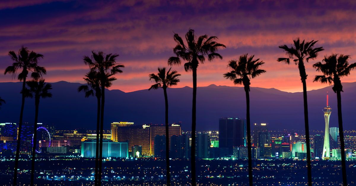 Las Vegas skyline at sunset with palm trees in the foreground