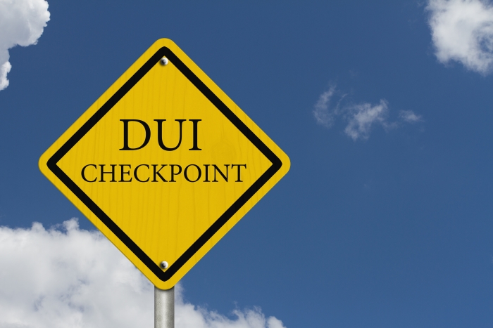 An American road warning sign with words DUI Checkpoint with blue sky