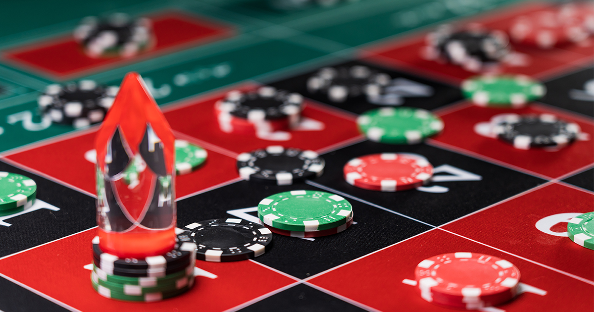 Close-up of a roulette table with colored chips and a red crystal marker