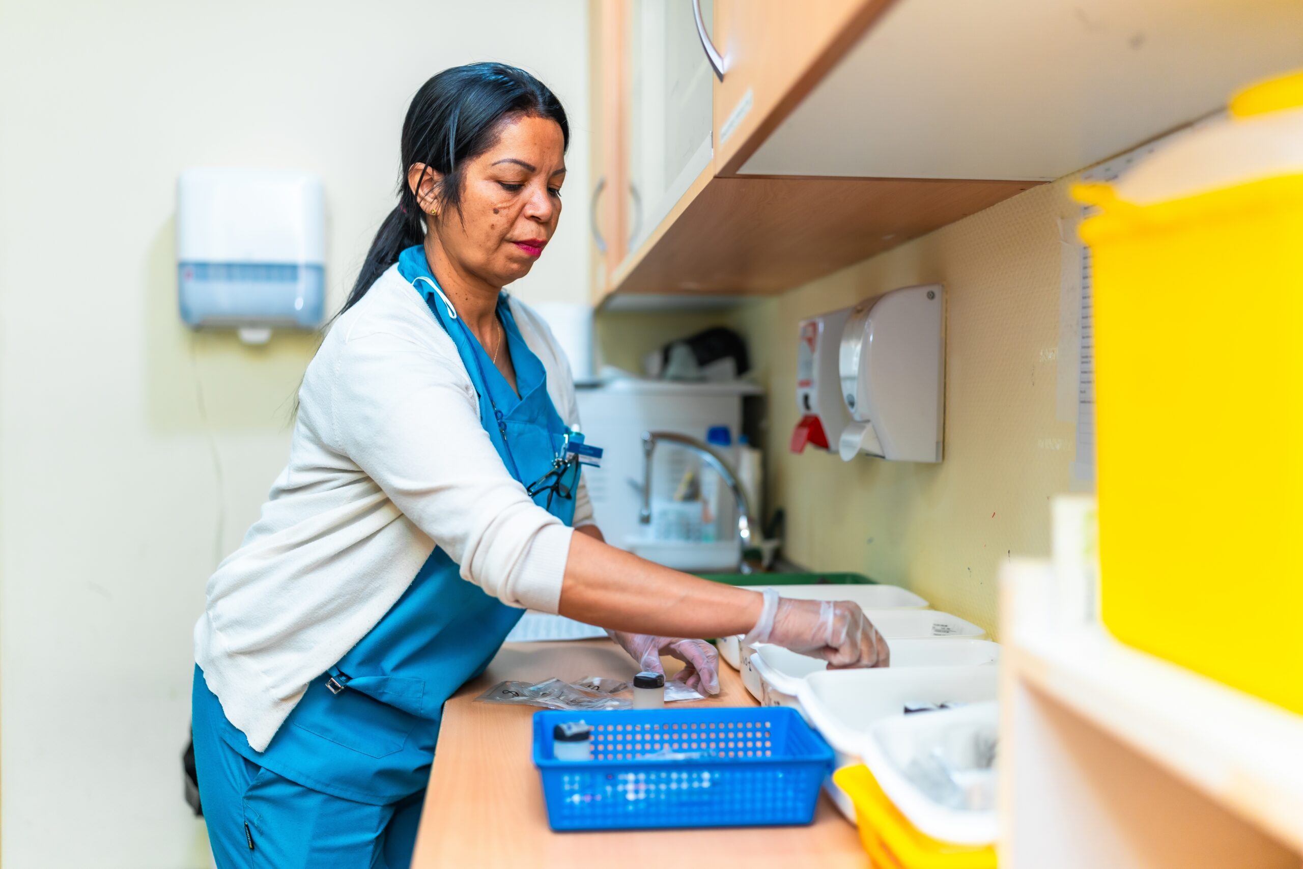 Nurse wearing gloves is preparing medication for patients.